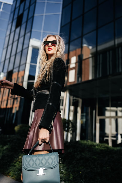 穿着黑色夹克的迷人长腿女士在街上摆姿势图片下载