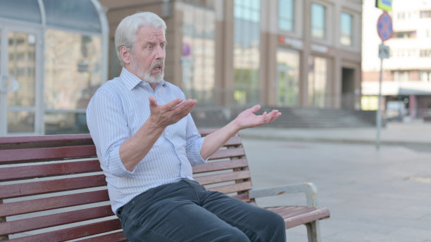 紧张的老人坐在户外长凳上感到沮丧图片下载