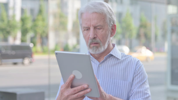 老人的肖像使用数字平板户外图片下载