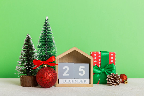 12月25日。圣诞作文在彩色背景用木制日历，用礼品盒，玩具，小摆设复制空间图片下载