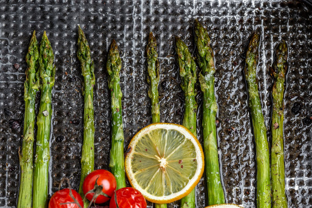 绿芦笋茎和柠檬一起炒。食物配方背景。近距离图片下载