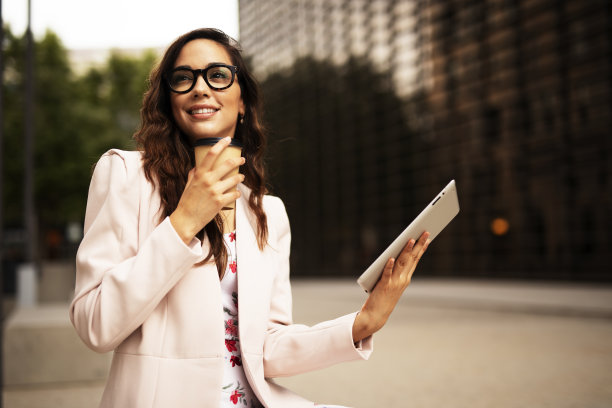 年轻的女商人在户外使用平板电脑。图片下载