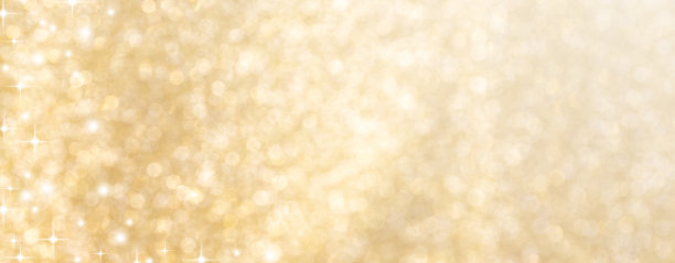 抽象模糊美丽发光的金色背景与圆形散焦光和闪亮的星星闪闪发光的圣诞节日和快乐的新年季节设计作为旗帜的概念图片下载