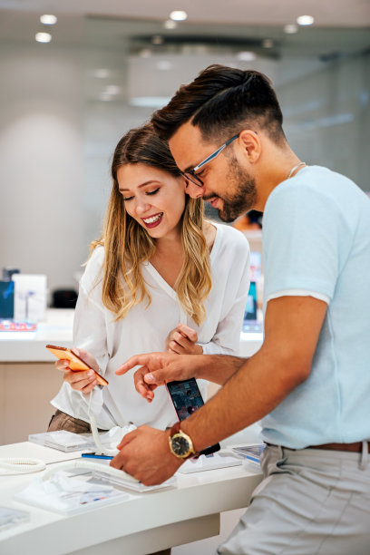 快乐的年轻人在商店里购买新手机。人技术装置新概念图片下载