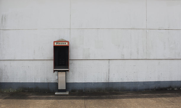 废弃大楼墙上的破电话亭图片下载