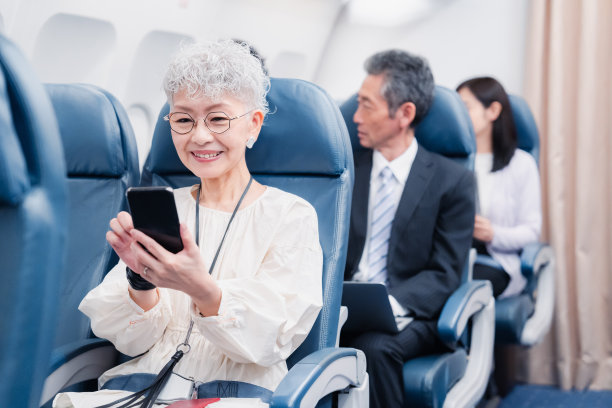 老年妇女在飞机上使用智能手机图片下载