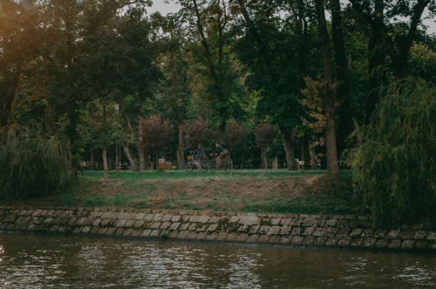 两个人在湖边的公园里骑自行车的照片图片下载