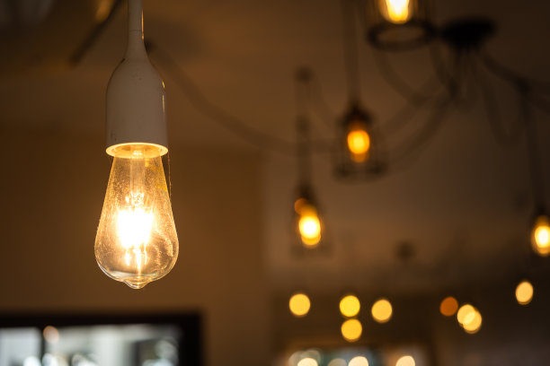 在温暖的光线下发光的天花板灯泡。图片下载