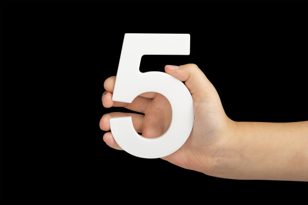 在黑色背景上，手里拿着五号。一个孩子手里拿着一张黑色背景的五号。插入:插入到一个项目或设计中图片下载