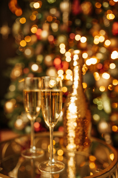 香槟酒瓶和玻璃杯配上奢华的霞光金雨装饰昂贵的假日派对图片下载