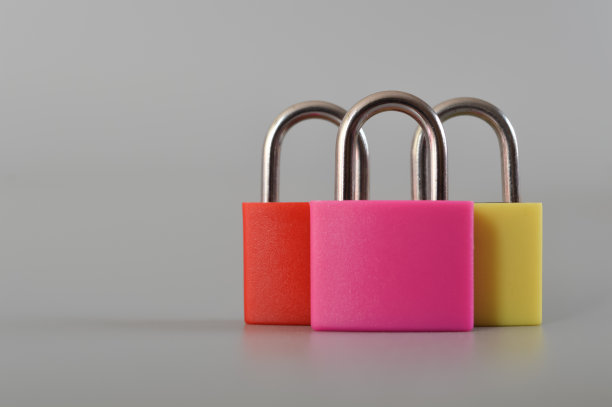 红色、粉色和黄色的挂锁孤立在灰色的背景上。图片下载