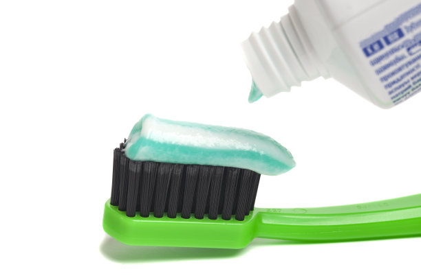 白色背景的牙刷挤牙膏特写。图片下载