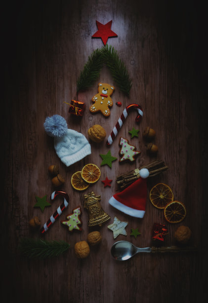 用不同的装饰品做成的圣诞树。在木制背景上。图片下载