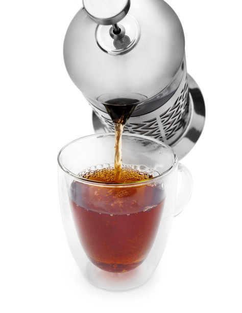 把热茶从茶壶倒到玻璃杯里。隔离在白色上。图片下载