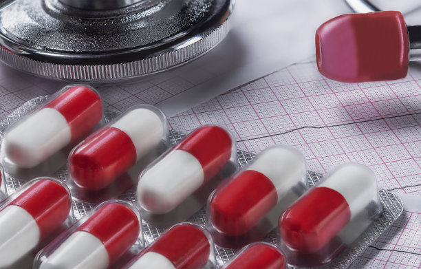 心电图背景上的药片。心血管疾病用制剂。图片下载