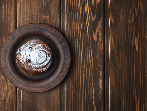 面包放在盘子上，放在木制的背景上。图片下载