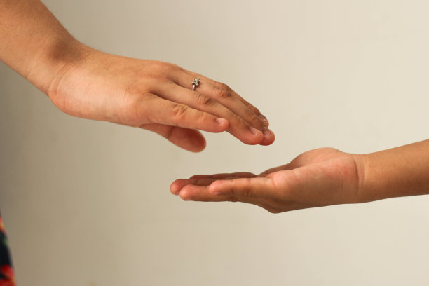 姐姐的手正要和弟弟单独握手。支持和帮助的概念。副本的空间。图片下载