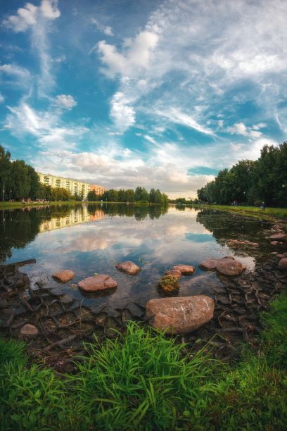 傍晚的大安格斯基池塘，石头，多云的天空倒映在水中，莫斯科，俄罗斯图片下载