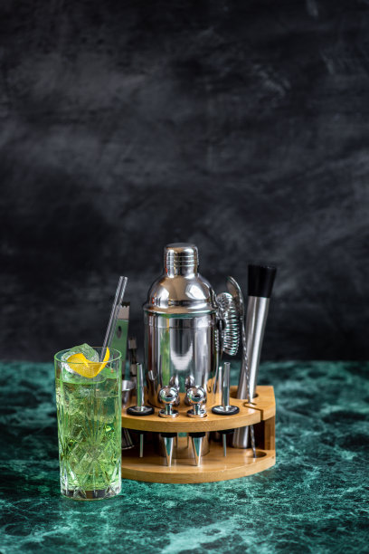 绿鸡尾酒杜松子酒罗勒粉碎在长饮杯与酒吧设备摇床和过滤器图片下载