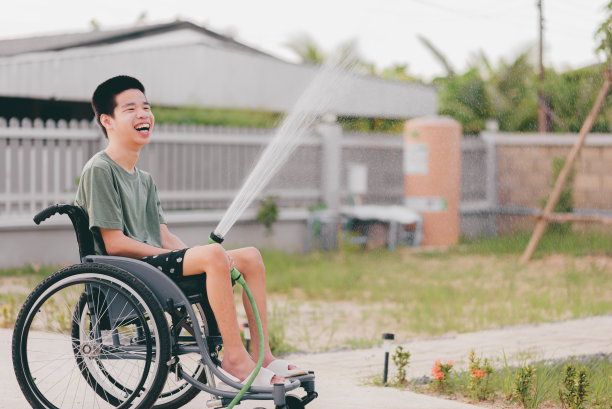 残疾青年在轮椅上的户外活动。图片下载
