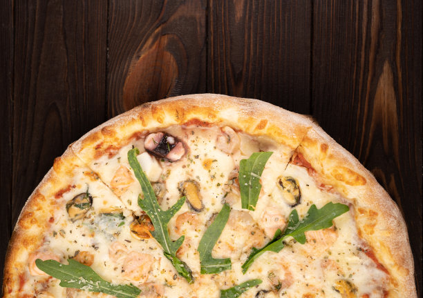 海鲜披萨搭配马苏里拉奶酪，各种海鲜和芝麻菜。图片下载