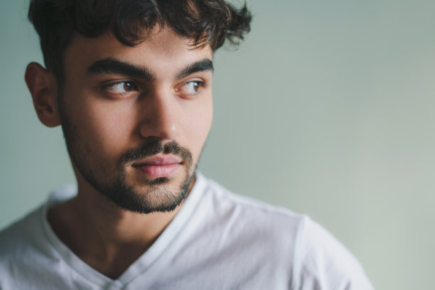 肖像沉思的人看向远方站在家里孤立的绿色墙。人们的生活方式。男人肖像。特写肖像。图片下载