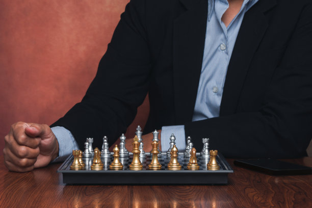 商人坐在办公室里，在棋盘上下棋图片下载