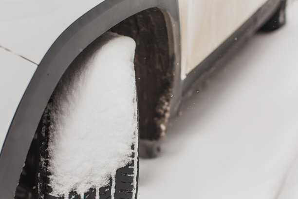 汽车车轮特写。雪下的汽车。冬天的天气。气候。风暴。运输图片下载