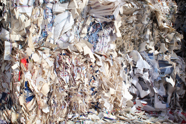 废纸在分拣厂堆成密实的堆，以便回收。材料再利用技术。碎纸堆图片下载