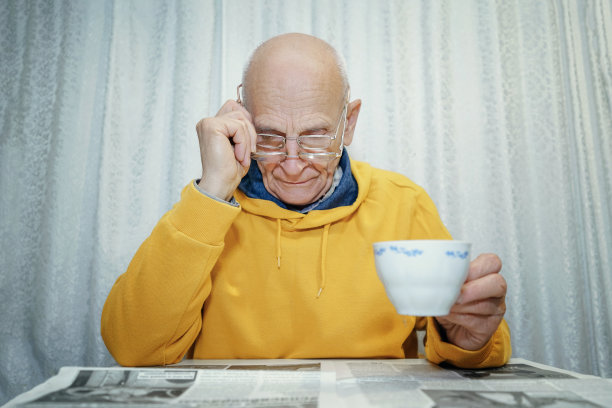 爷爷戴着双层眼镜看报纸图片下载