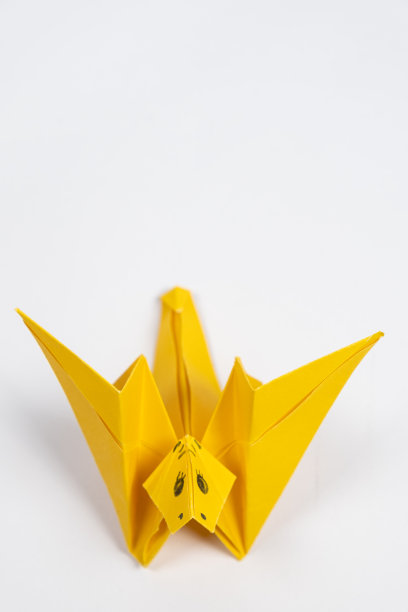 折纸黄色可爱的龙，白色背景的纸动物雕像图片下载