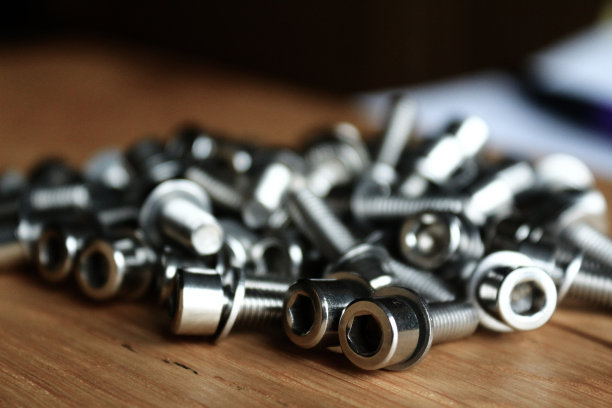 照片特写-内六角扳手用不锈钢螺丝-在背景模糊的木桌上图片下载