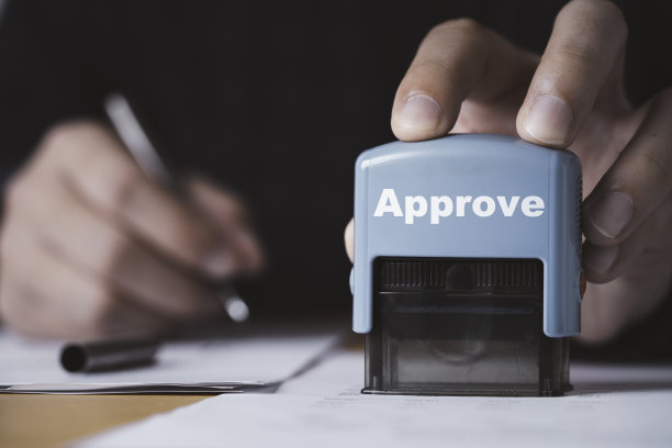 商业许可证和ISO证书概念的审批文件的手动盖章特写。图片下载