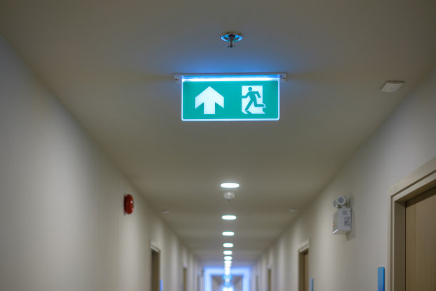 建筑物内部墙壁背景上的消防紧急出口标志。安全的概念图片下载