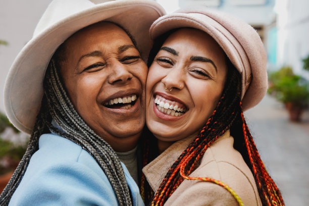 快乐的非洲母亲和成年的女儿在城市的寒假里拥抱在一起，微笑着在镜头前-家庭之爱图片下载