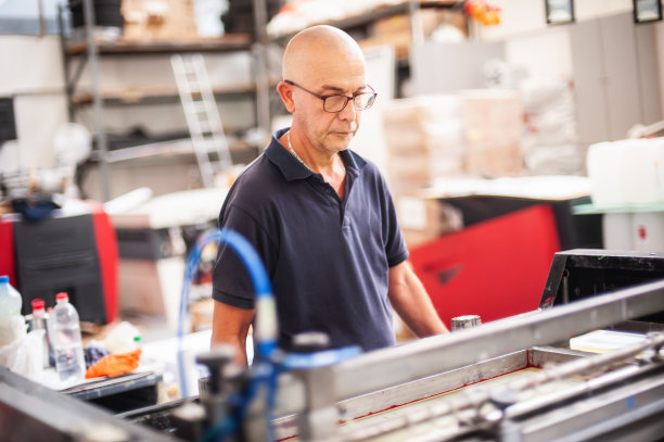 有经验的操作员在丝网印刷机上工作图片下载