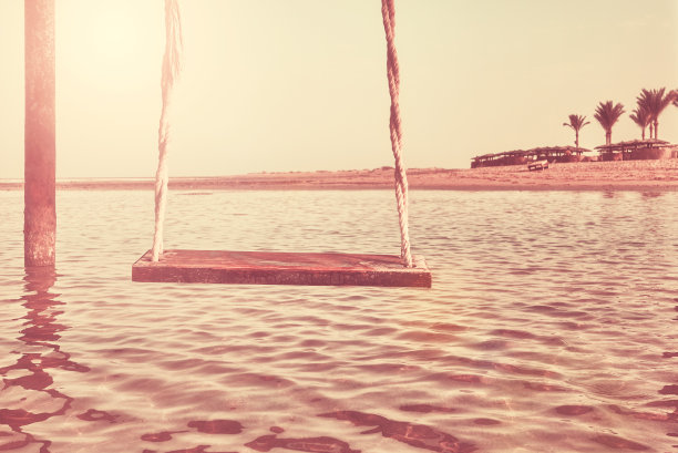 海滩上的旧木秋千。图片下载