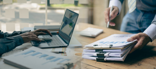 商务会议概念市场财务分析师在公司会议上讨论时用笔记本电脑分析商业财务报告，展示了成功的团队合作。结合照片图片下载