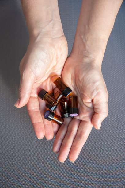 一个女人手里拿着很多装着精油的玻璃瓶图片下载