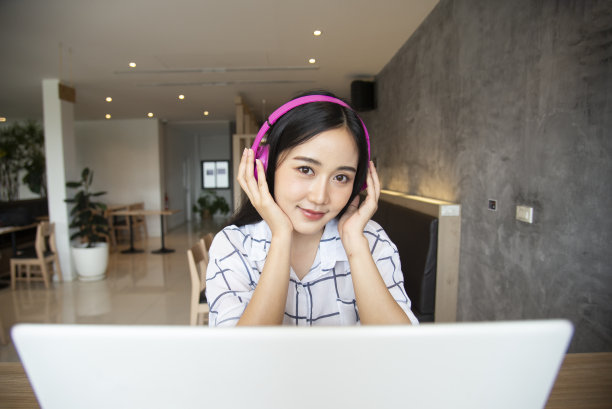 年轻女子高兴地听音乐，在家里的客厅工作，放松和放松。生活方式的概念图片下载