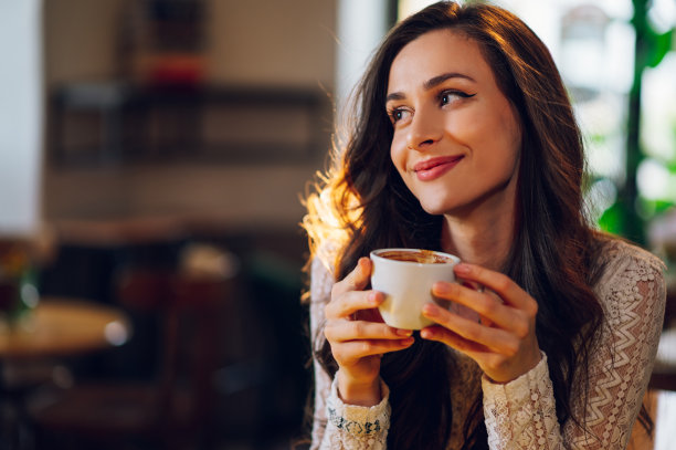 美丽的年轻女子在咖啡馆喝咖啡或茶的肖像图片下载