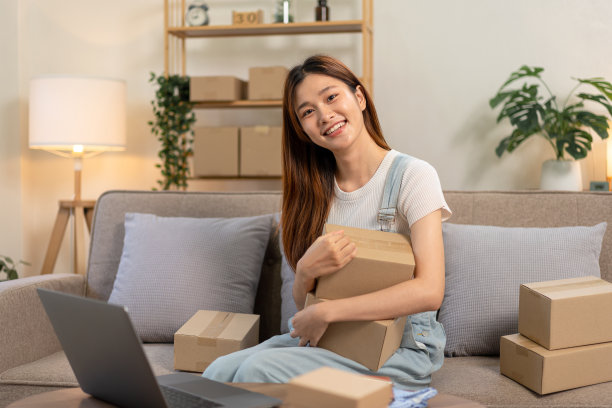 年轻的企业家抱着纸板箱，坐着准备给顾客送货上门图片下载