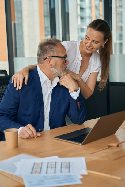 年轻女子在工作日拥抱成熟的老板图片下载