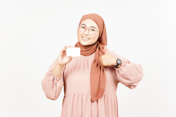 持有空白的银行卡或信用卡的美丽的亚洲妇女戴头巾隔离在白色图片下载