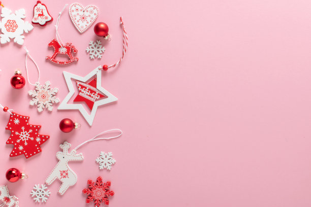 圣诞构图与红色和白色的圣诞树生态玩具在左边的浅粉色背景。新年快乐，圣诞快乐。复制空间。平放位置，俯视图图片下载