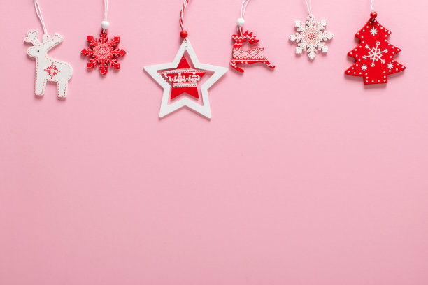 圣诞构图与红色和白色的圣诞树玩具在顶部的浅粉色背景。图片下载
