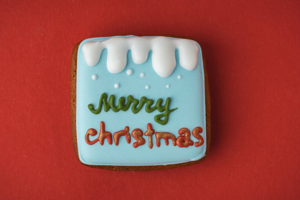 来自降临节日历的美味圣诞饼干，让你在期待圣诞节的时候数着日子。姜饼饼干，红色背景上有节日糖霜。圣诞快乐，新年快乐图片下载