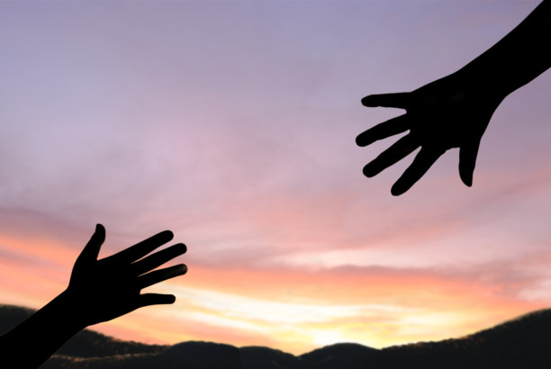 援助之手的轮廓概念。伸出援助之手，在自然清晨的阳光下相互希望和支持。国际和平日。请帮帮我。图片下载