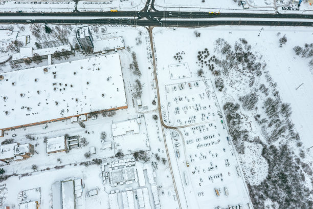 工业区的停车场。一排排被雪覆盖的汽车。鸟瞰图。图片下载