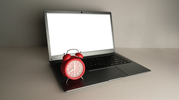 笔记本电脑和红色闹钟。图片下载